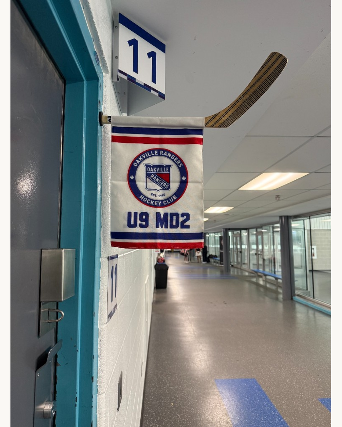 Custom hockey change room door flag hanging beside room 11